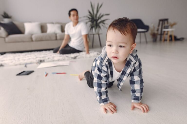Crawling baby exploring a living room while a parent watches — a baby-proofing scene — photo by Gustavo Fring on Pexels