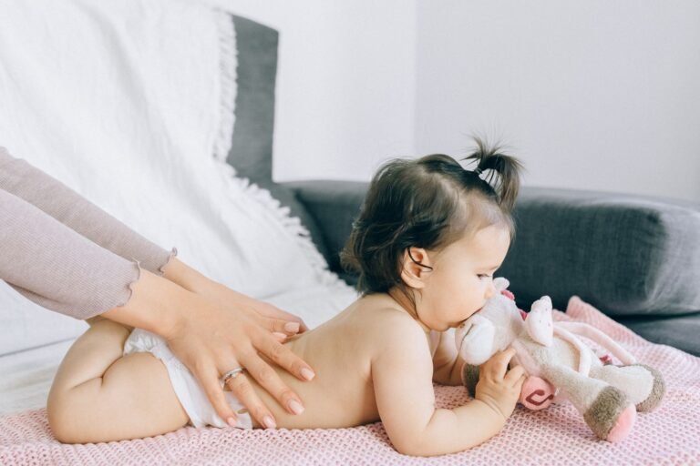 Parent gently applying lotion during a baby massage