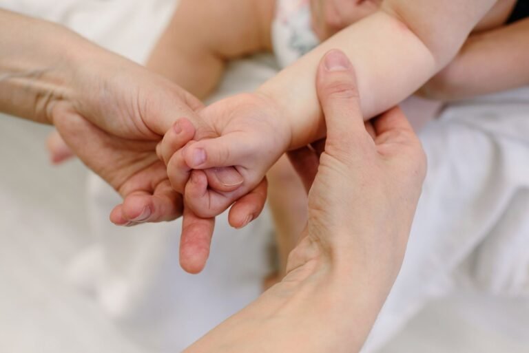 A parent gently massaging lotion into a baby's arm