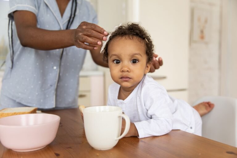Toddler reaching up at a kitchen table with a parent nearby — babyproofing picks Canada 2026, photo by KATRIN BOLOVTSOVA on Pexels