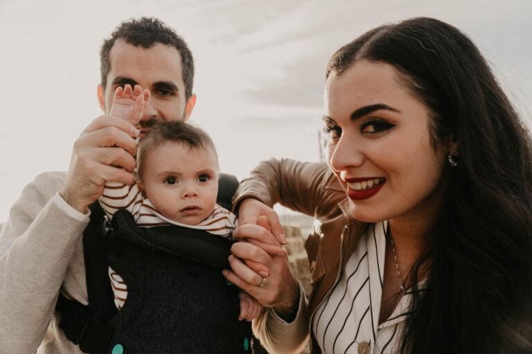 Parent carrying a baby in a soft carrier outdoors