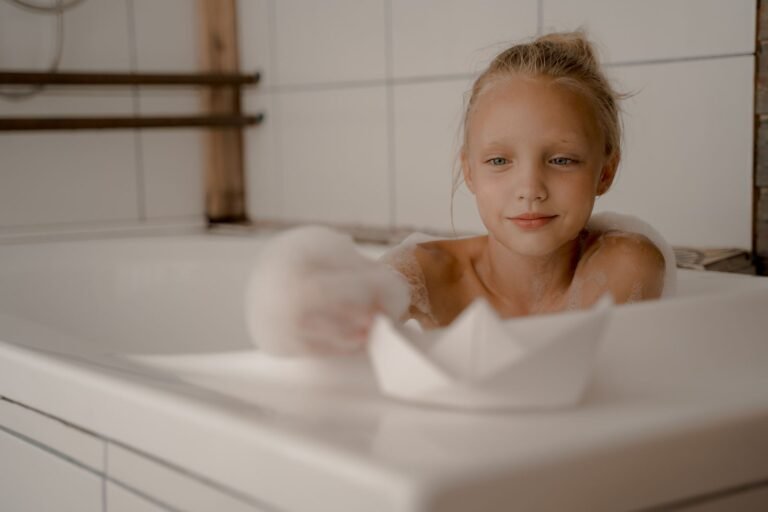 Baby playing with a toy in a bubble-filled bathtub