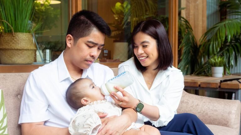 Parents bottle-feeding their baby at home