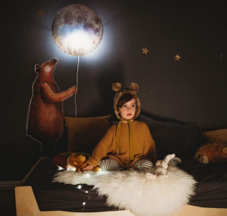 Child settling into bed in a softly lit bedroom at night