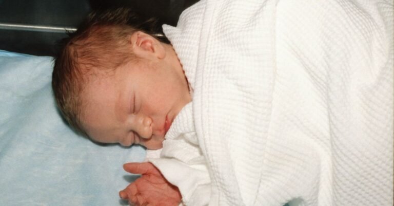 Newborn baby swaddled in a soft cotton blanket, sleeping peacefully