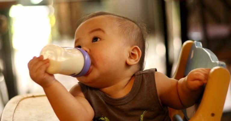 Parent bottle-feeding a baby indoors — Dr. Brown's vs Tommee Tippee anti-colic bottle comparison