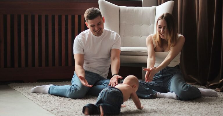 Young parents on a living room rug watching their crawling baby — the stage when most families put up a baby gate