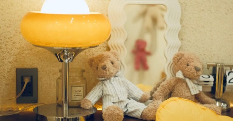 Nursery at night with a soft lamp and teddy bears — Yogasleep Dohm vs Hatch Rest sound machine comparison 2026